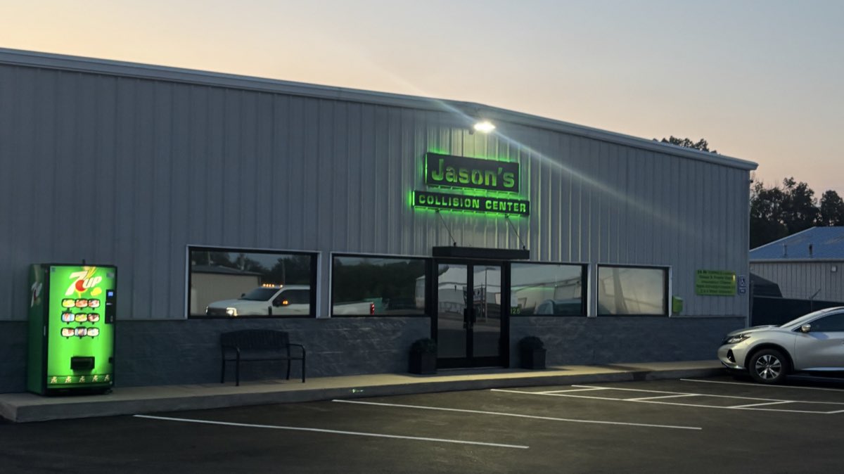 Jason's Collision Center storefront at dusk, green neon sign glowing